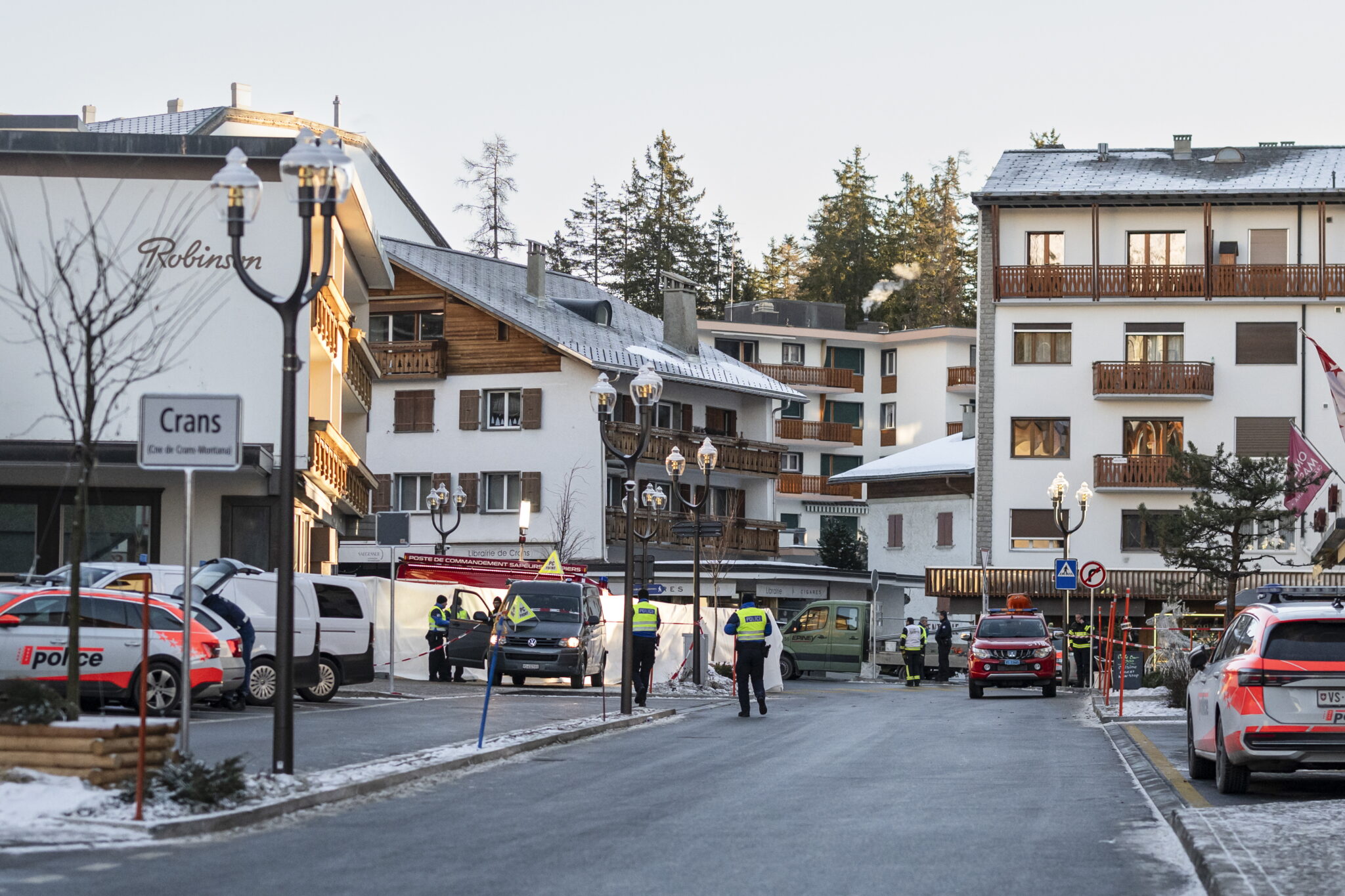 epa12620167 Police officers stand near the site where a fire broke out at Le Constellation bar and lounge following an explosion in the early hours of New Year's Eve, in Crans-Montana, Switzerland, 01 January 2026. According to regional media, the incident caused several deaths and injuries, while the exact cause of the blaze was not immediately known, Swiss cantonal police said. EPA/ALESSANDRO DELLA VALLE